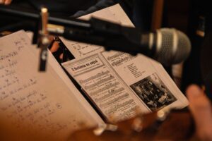 Close-up of sheet music with a microphone in a performance setting, capturing a musical moment.